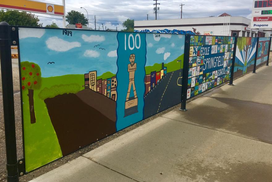 Artwork being displayed on a fence.